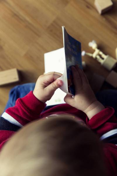 infant boy reads book/